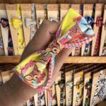 Fita para cabello con diseño de personajes infantiles y estampado colorido.