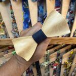 Lafio de madera en forma de pajarita con el centro en tela azul oscuro.