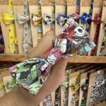 Coloridos lazos de tela con personajes de dibujos animados y videojuegos en tienda de accesorios.