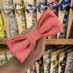 Banda para cabello con lazo en color coral, ideal para peinados divertidos y elegantes.