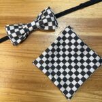 Corbata y pañuelo de moño a cuadros en negro y blanco para evento elegante y moderno.