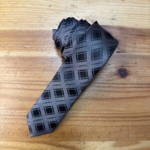 Cinturón de seda gris con diseño geométrico negro para ocasiones formales y elegantes.