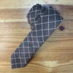 Corbata de cuadros gris y blanco, elegante y moderna para ocasiones formales.