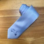 Corbata azul con logotipo, ideal para vestir elegante y moderna. Complemento perfecto para eventos y ocasiones especiales.