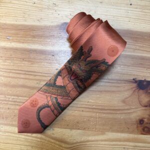 Corbata de seda con estampado de dragón en tonos naranjas y negros, elegante y moderna para eventos formales.