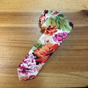 1. Corbata de seda con estampado floral en tonos vibrantes y fondo blanco.