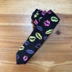 Corbata con estampado de labios en colores neón sobre fondo negro, accesorios moda femenina moderna y elegante.
