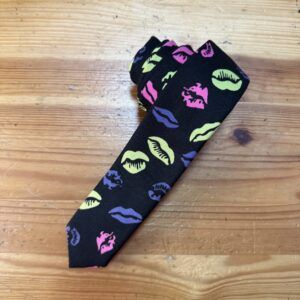 Corbata con estampado de labios en colores neón sobre fondo negro, accesorios moda femenina moderna y elegante.