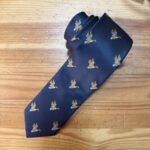 Corbata azul con patrón de patos en tonos dorados y azules, perfecta para looks elegantes y sofisticados.