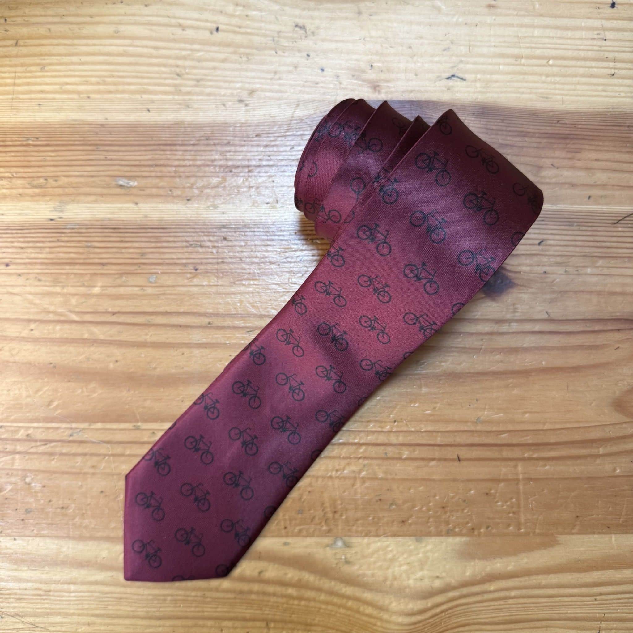 Corbata burdeos con motivo de bicicletas negras, elegante y moderna para ocasiones especiales.