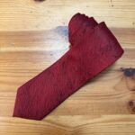 Lazo de raso rojo con bordado floral para decoración y costura artística.