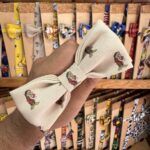 1. Lazo de tela con estampado de personajes infantiles, ideal para accesorios de moda y regalos.
