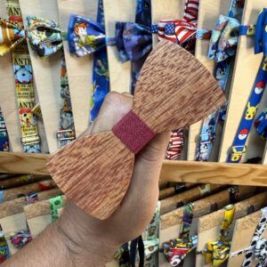 1. Corbatín de madera con tira de tela en color burdeos, estilo artesanal y elegante.