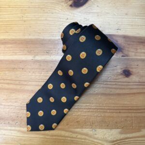 Elegante corbata de seda negra con patrón de botones dorados, perfecta para ocasiones formales.