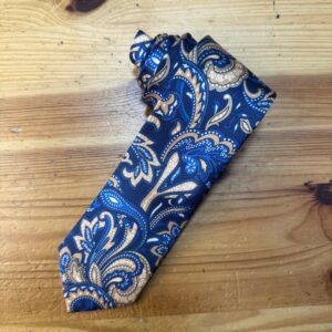 Corbata de seda con estampado de estilo paisley en tonos azules y beige.