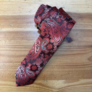 Corbata de seda con estampado bandana en tonos rojos y negros para estilo elegante y moderno.