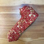 1. Pañuelo de tela con estampado floral en color rojo y oro elegante.