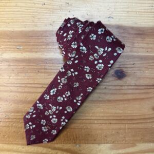 Corbata de seda burdeos con estampado floral en tonos beige y blanco, elegante y exclusiva para ocasiones especiales.