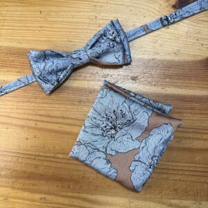 Lazo de moño y pañuelo de seda con diseño floral en tonos azules y beige. Perfectos accesorios para ocasiones especiales.