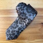 Elegante monedero de seda con diseño floral gris y negro, ideal para accesorios de moda y uso diario.