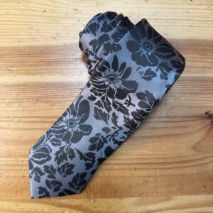 Elegante monedero de seda con diseño floral gris y negro, ideal para accesorios de moda y uso diario.