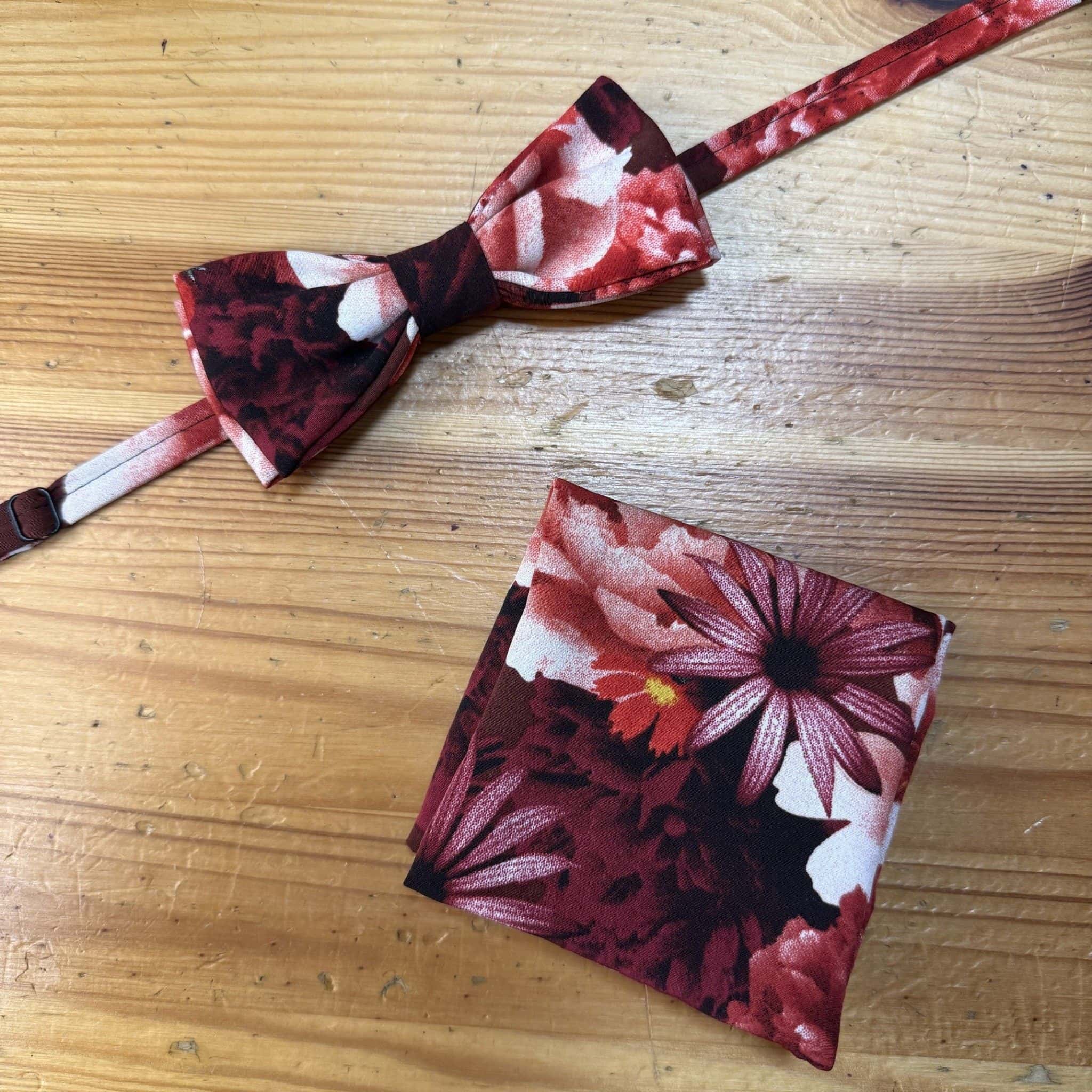 Corbata y paño bordado con flores en tonos rojos y rosados, accesorios de moda para ocasiones elegantes.