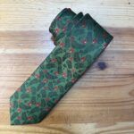 Corbata con estampado tropical de hojas y flores rojas, ideal para ocasiones formales y con estilo natural.