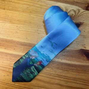 Corbata estampada con escena natural y mujer en campo de flores en tonos azules.