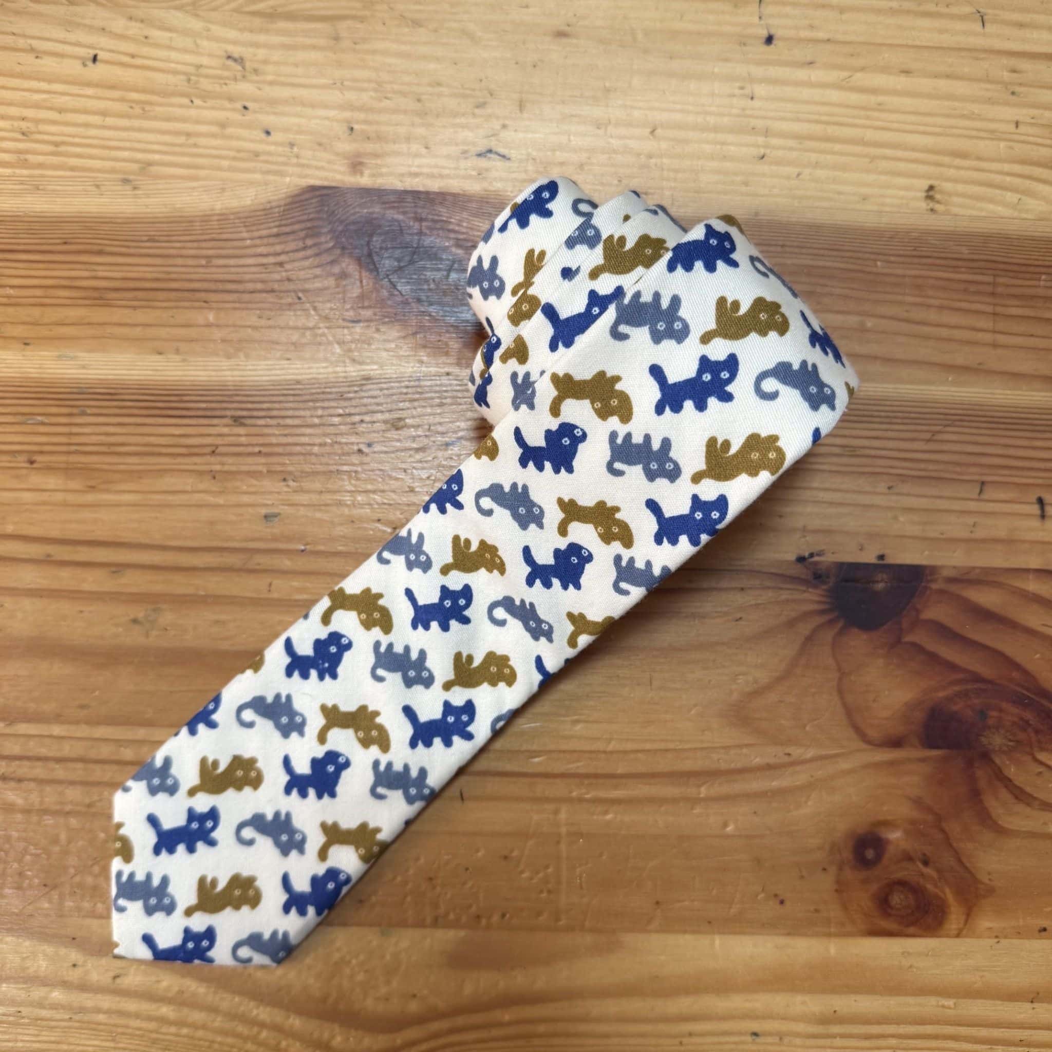 Patucos para bebé con dibujos de lagartos en color azul y marrón, hechos a mano. Perfectos para regalar y mantener la comodidad del bebé.