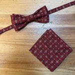 Corbata de pajarita y pañuelo estampados en color burdeos con patrón de flores y puntos para ocasiones elegantes.