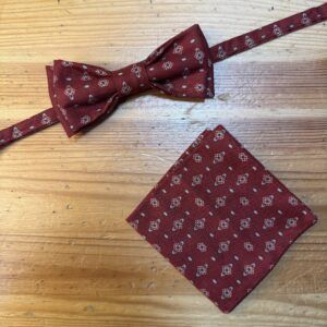 Corbata de pajarita y pañuelo estampados en color burdeos con patrón de flores y puntos para ocasiones elegantes.