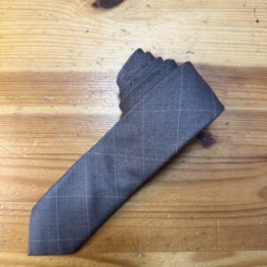 Elegante corbata de lino gris con discreto calcetín con cuadros blancos. Ideal para look formal y sofisticado.
