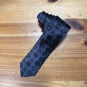 1. Corbata negra con diseño geométrico en tonos oscuros perfecta para eventos elegantes.