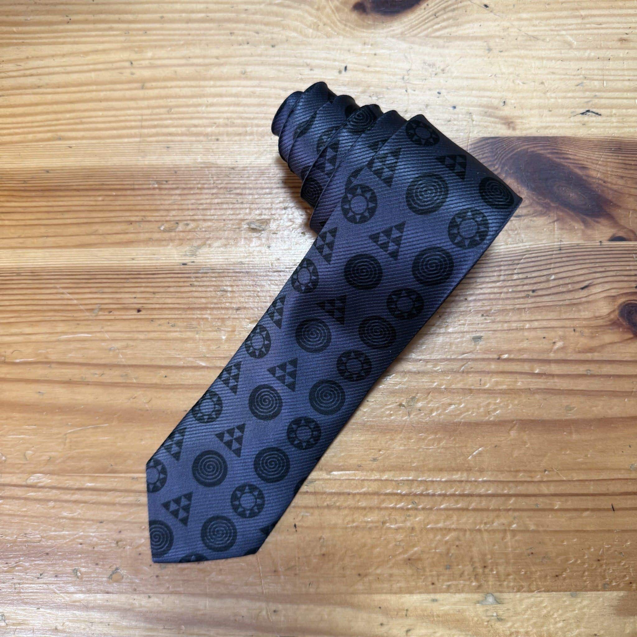 1. Corbata negra con diseño geométrico en tonos oscuros perfecta para eventos elegantes.