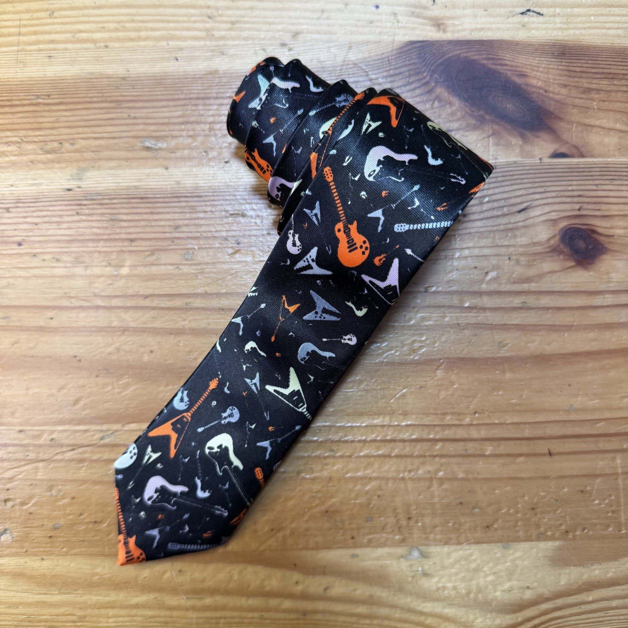 Goma de mascar con diseño musical y guitarra en colores naranja, negro y gris.