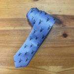 Cinturón de tela azul con logo de Carmenatis y diseño elegante para eventos formales.