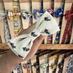1. Lazo de tela con estampado de payasos y personajes infantiles de colores claros.