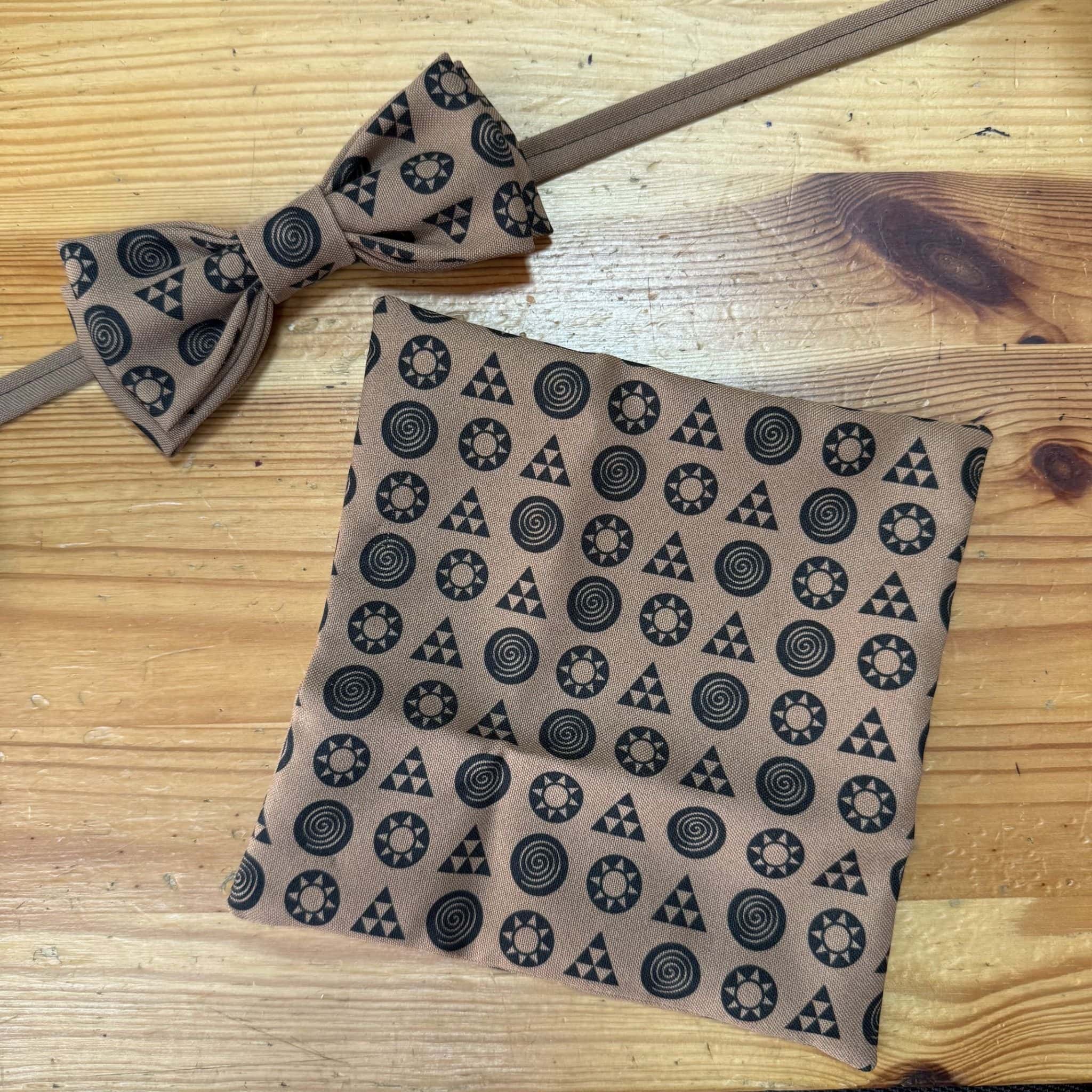 Banda y pajarita de tela con diseño geométrico en tonos beige y negro, complementos de moda artesanal.