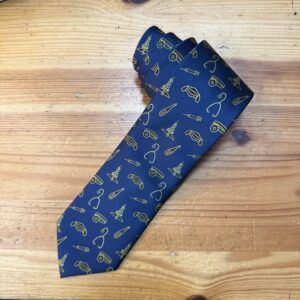 Corbata azul con estampados de instrumentos médicos y logo de Carmenatis, ideal para profesionales de la salud.