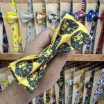 Colorido lazo para mascotas con diseño de león en fondo amarillo, ideal para complementar el estilo de tu mascota.