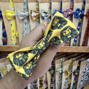 Colorido lazo para mascotas con diseño de león en fondo amarillo, ideal para complementar el estilo de tu mascota.