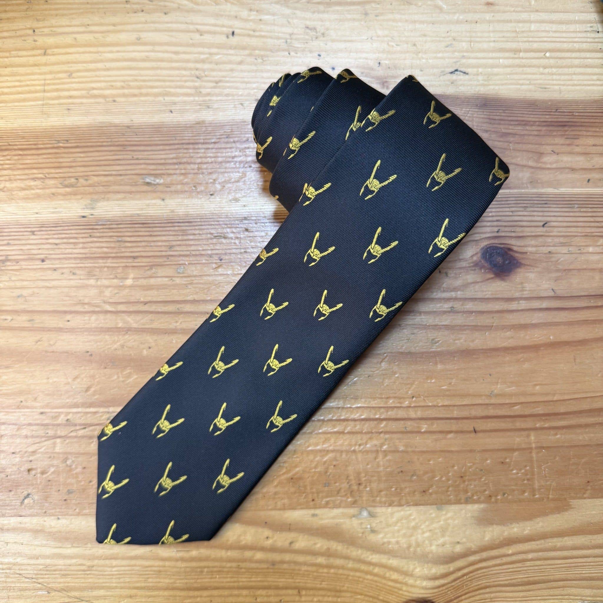 Corbata negra con logo dorado de diseñadora española Carmenatis. Perfecta para ocasiones formales y eventos profesionales.