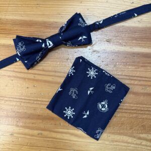 Corbata y pañuelo marinero en color azul con motivos de anclas y timones, estilo náutico, para hombre y mujer.