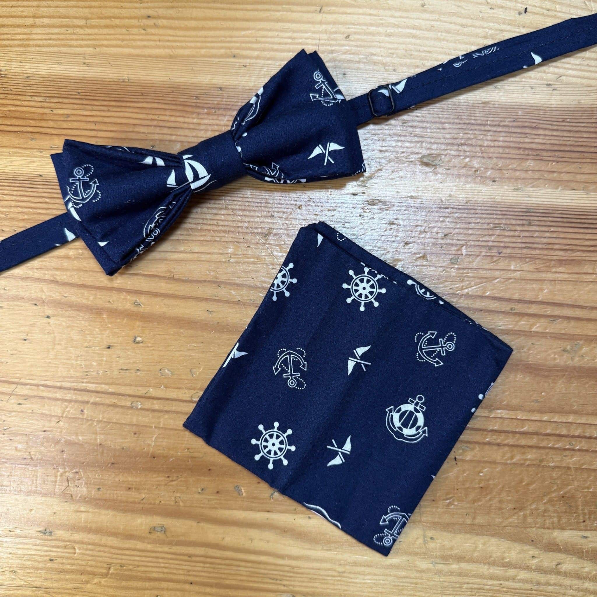 Corbata y pañuelo marinero en color azul con motivos de anclas y timones, estilo náutico, para hombre y mujer.