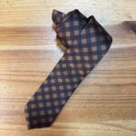 Corbata de rayas en tonos marrón y negro, estilo clásico y elegante.