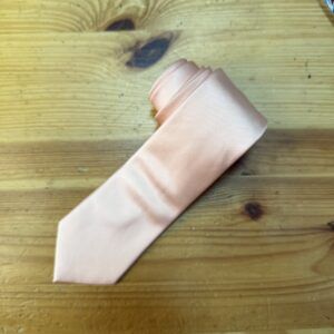 Cinta de seda rosa en mesa de madera, accesorios de belleza y moda.