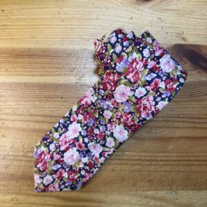 1. Funda de tela con estampado floral en tonos rosas, púrpuras y verdes sobre fondo oscuro.