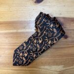 Tocado de mujer con estampado en negro y dorado, elegante y sofisticado para ocasiones especiales.