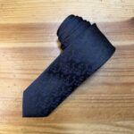 Elegante corbata negra con estampado sutil para ocasiones formales y empresariales.