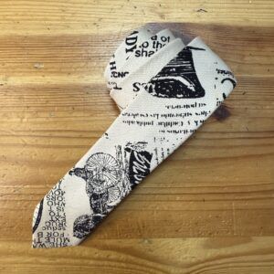 Bucle de tela con estampado vintage de texto y bicicletas, ideal para proyectos de costura y manualidades creativas.
